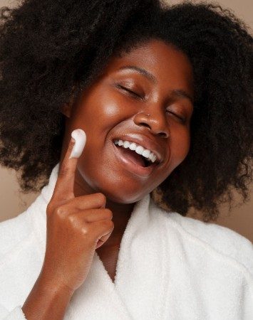 Une femme africaine qui hydrate sa peau