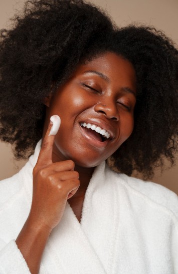 Une femme africaine qui hydrate sa peau