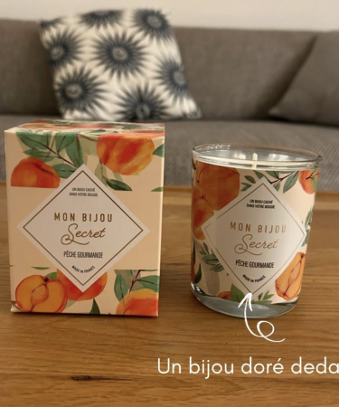 Bougie parfumée artisanale contenant un bijou surprise à l’intérieur, posée sur une table
